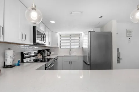 a kitchen with stainless steel appliances a refrigerator a sink a stove a microwave and cabinets