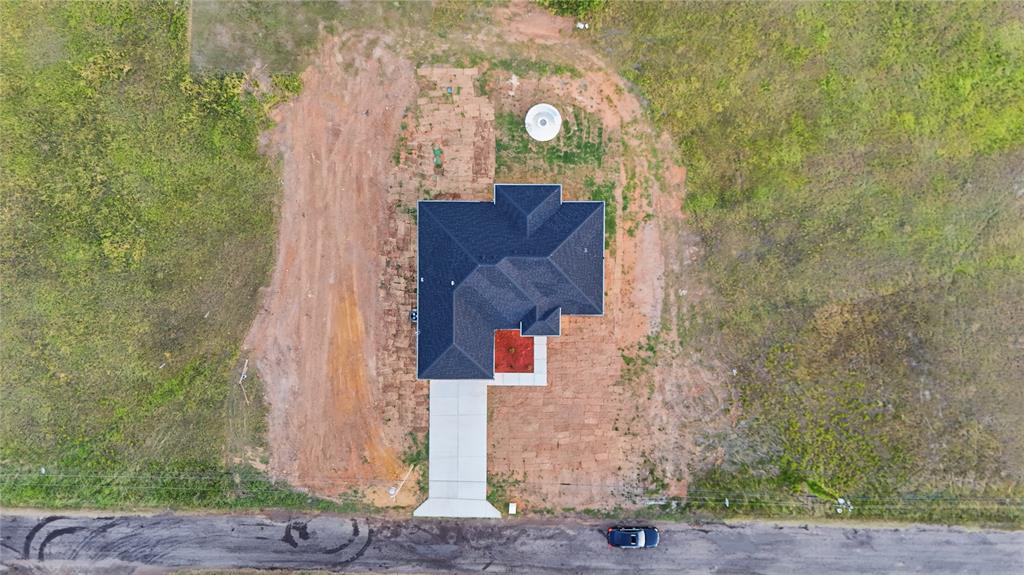 130 Cedar Elm Road Trinidad, TX 75163 - Photo 24 of 27 Newly constructed residence featuring a dark shingle roof and a light-colored concrete driveway
