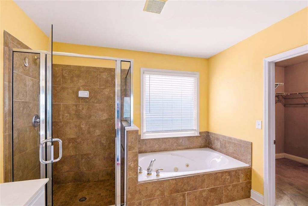 3420 Bulloch Lake Road Loganville, GA 30052 - Photo 40 of 57 a bathroom with a tub and a shower