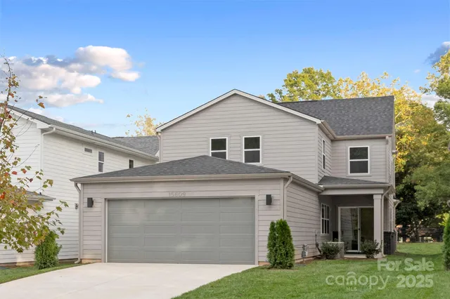 a front view of a house with a garden and garage