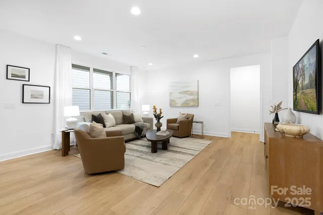 a living room with furniture wooden floor and a large window
