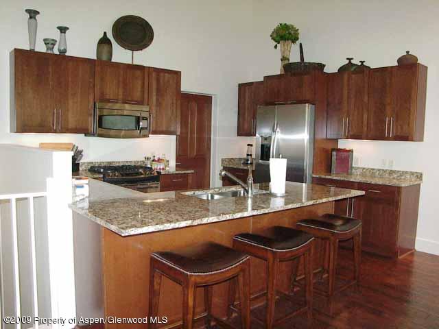 a kitchen with stainless steel appliances granite countertop a sink a stove and a refrigerator