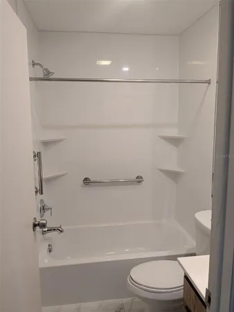 a bathroom with a shower a toilet and sink