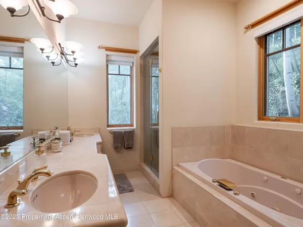 a bathroom with a tub sink and mirror