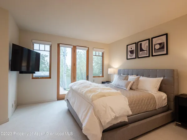 a bedroom with a bed and a flat screen tv