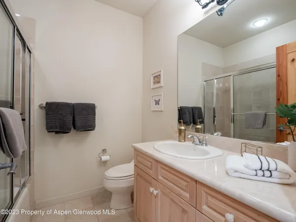 a bathroom with a granite countertop sink a toilet and a mirror