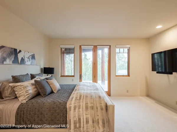 a bedroom with a bed and a flat screen tv