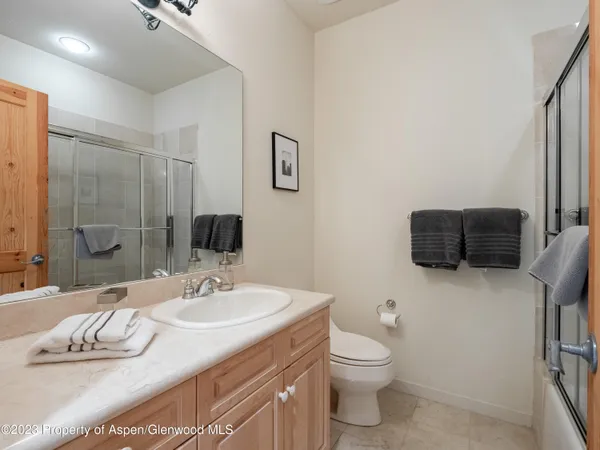 a bathroom with a granite countertop sink a toilet and a large mirror