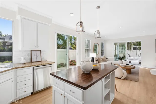 a open kitchen with granite countertop a sink and white cabinets