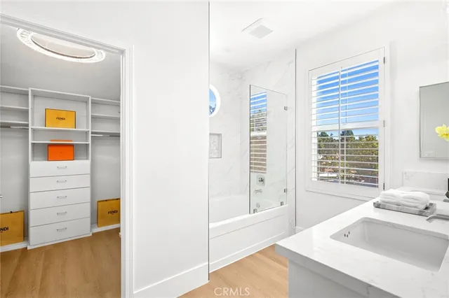 a bathroom with a tub a sink and a large mirror