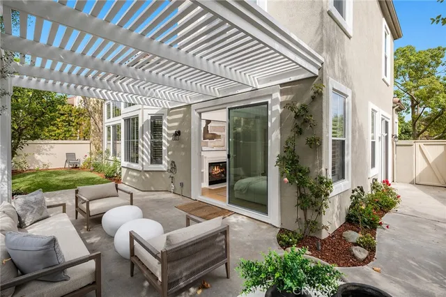 a view of a patio with couches table and chairs potted plants and floor to ceiling window