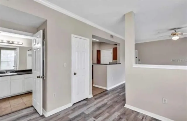 a view of a hallway with wooden floor and cabinet space