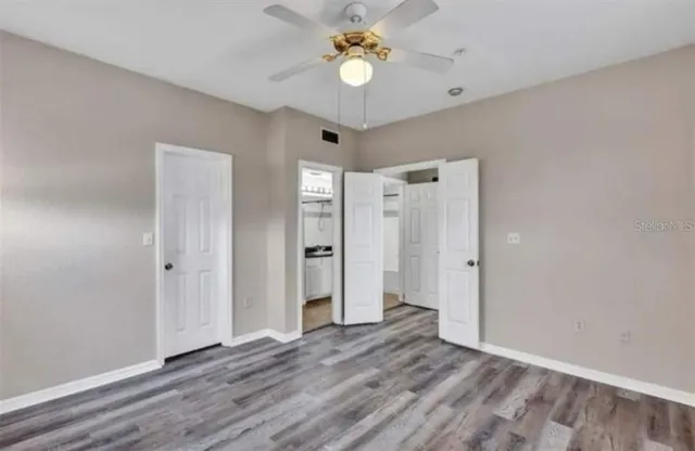 a view of empty room with wooden floor