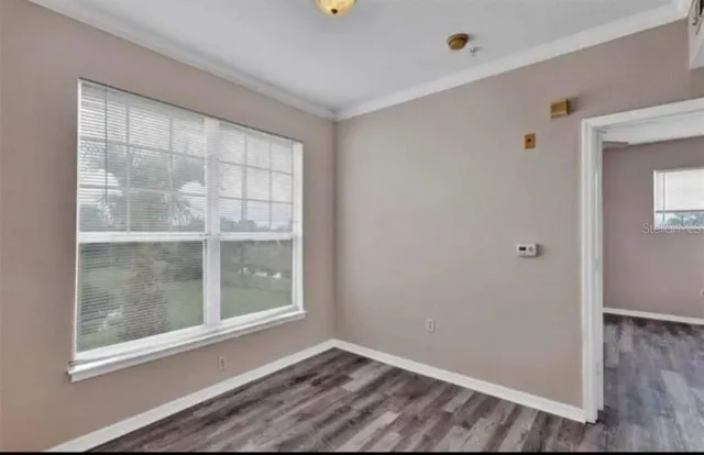 a view of empty room with window and wooden floor