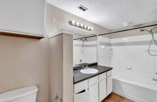 a bathroom with a double vanity sink a toilet a mirror and shower
