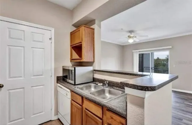 a kitchen with granite countertop a sink a stove and cabinets
