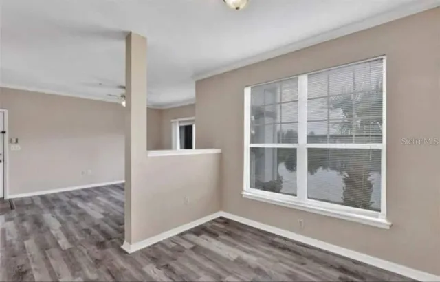 a view of a room with wooden floor and a window