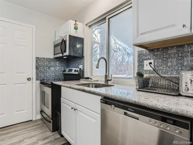 a kitchen with stainless steel appliances granite countertop a sink and a stove