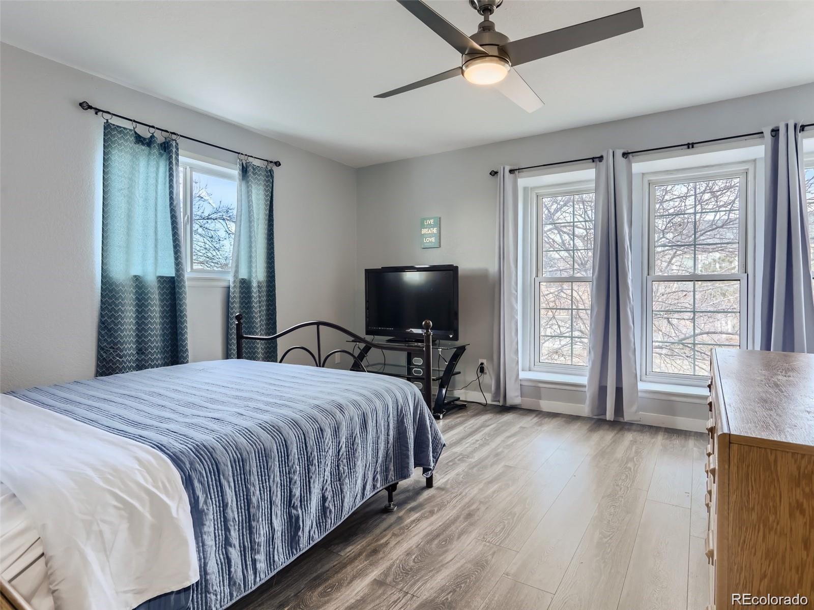 5941 South Perth Street Centennial, CO 80015 - Photo 16 of 28 a bedroom with a bed and a flat screen tv