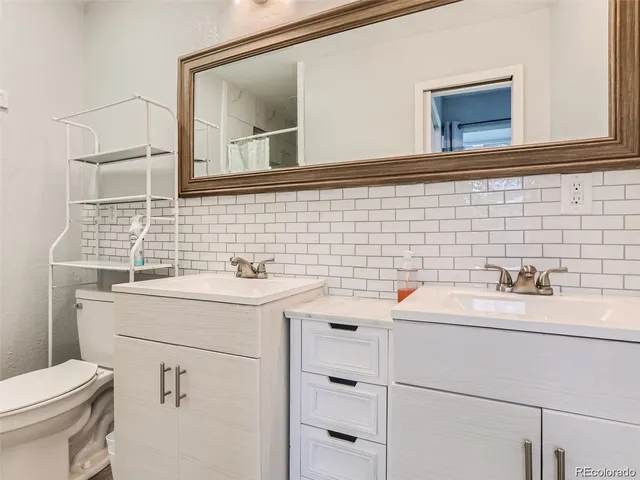 a bathroom with a sink toilet and mirror