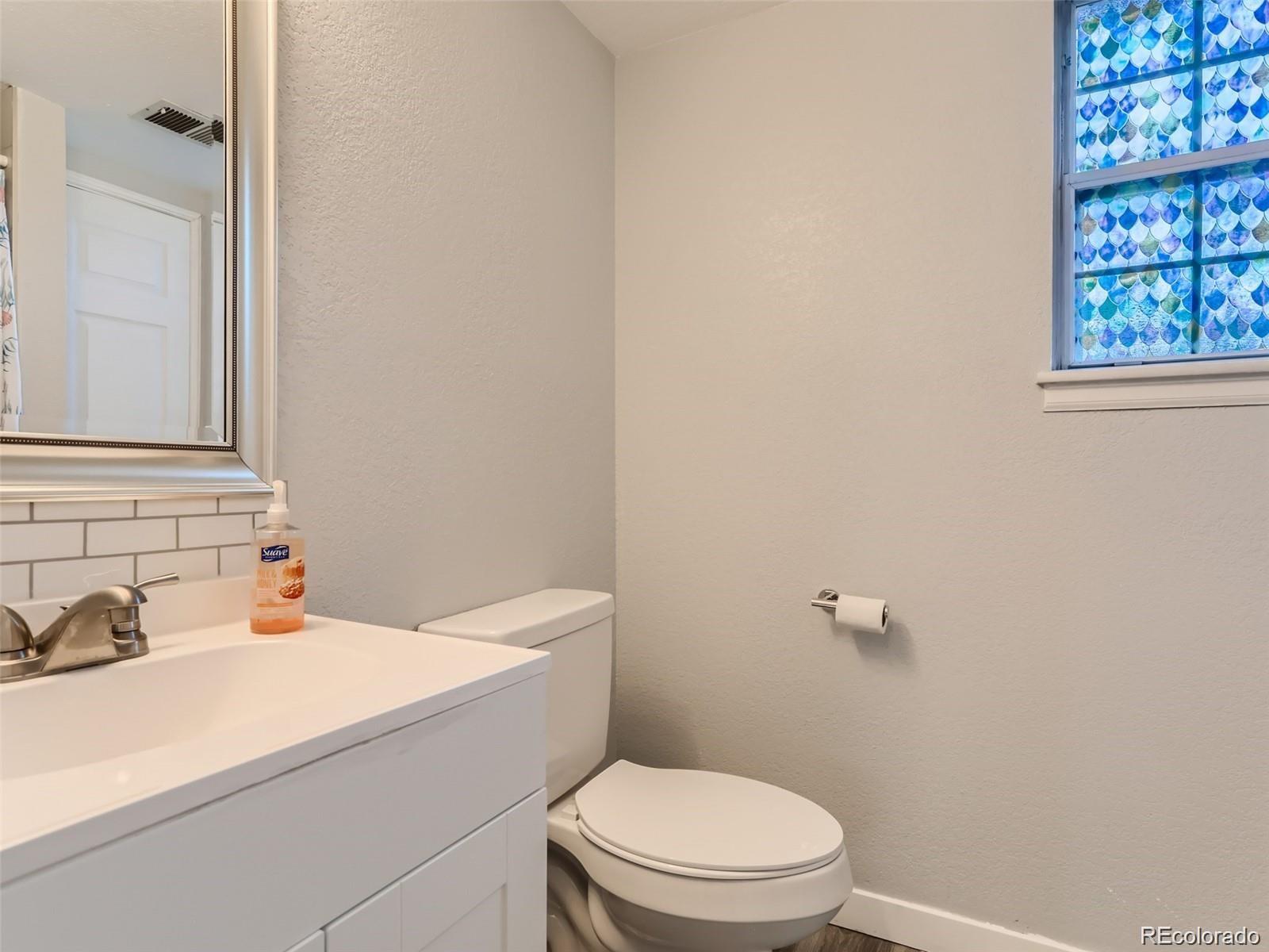 5941 South Perth Street Centennial, CO 80015 - Photo 23 of 28 a white toilet sitting next to a bathroom sink