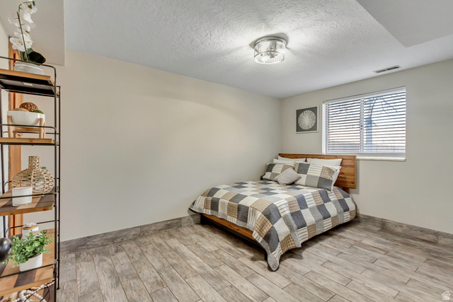 933 South Freedom Boulevard, Unit 7 Provo, UT 84601 - Photo 18 of 23 Bedroom with wood finished floors, a textured ceiling and new lighting