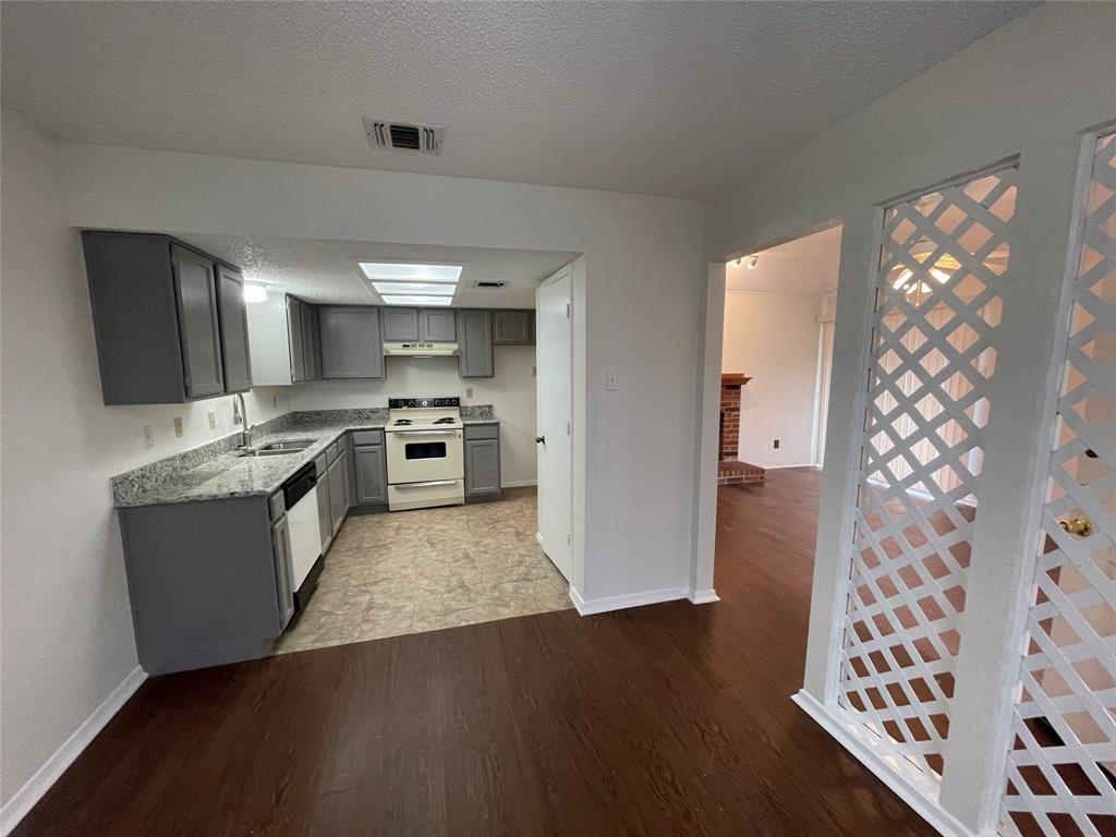 2510 Stanford Street, Unit A Rowlett, TX 75088 - Photo 6 of 11 a large kitchen with cabinets wooden floor and stainless steel appliances