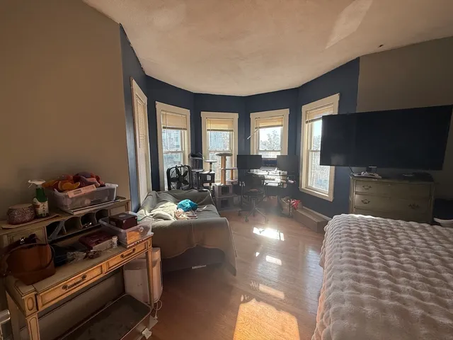 a living room with furniture a flat screen tv and a floor to ceiling window