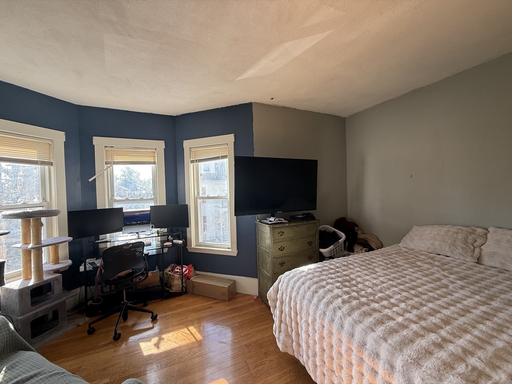 107 Bloomfield Street, Unit 3 Boston, MA 02124 - Photo 2 of 14 a bedroom with a bed and a flat screen tv