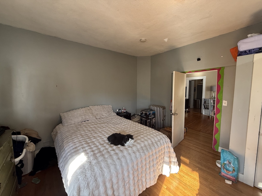 107 Bloomfield Street, Unit 3 Boston, MA 02124 - Photo 8 of 14 a bedroom with a bed and a chandelier