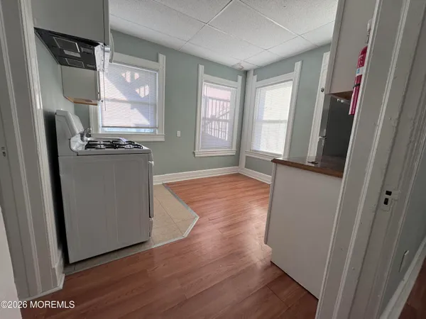 a kitchen with stainless steel appliances a refrigerator a stove a sink and white cabinets