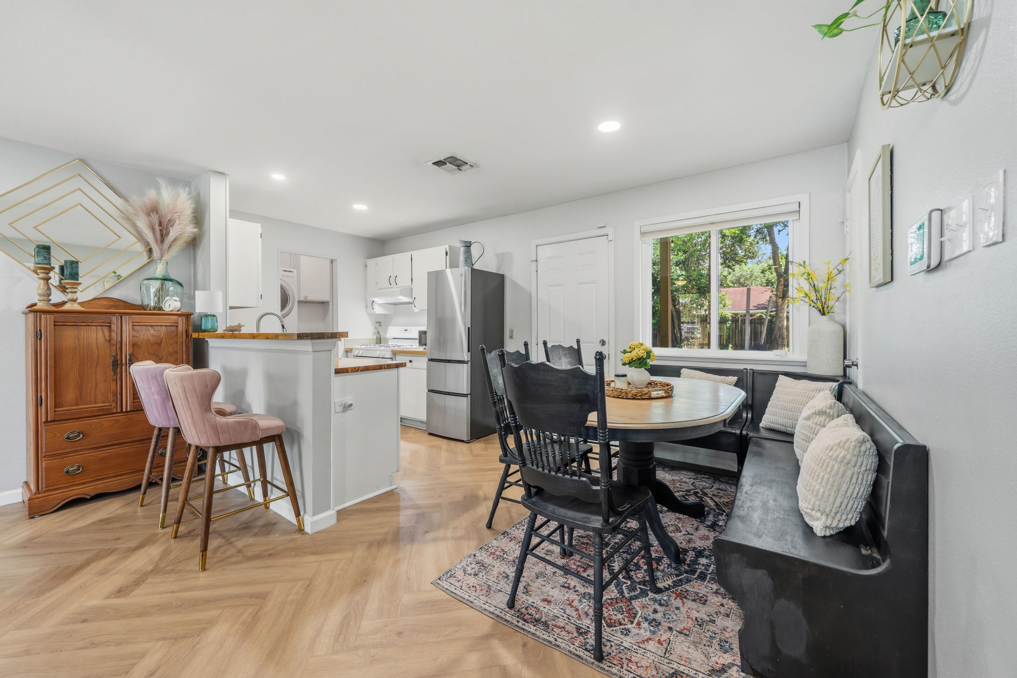 705 Dulwich Street Austin, TX 78748 - Photo 4 of 36 Herringbone flooring seamlessly connects the kitchen and dining areas in this bright, inviting space.