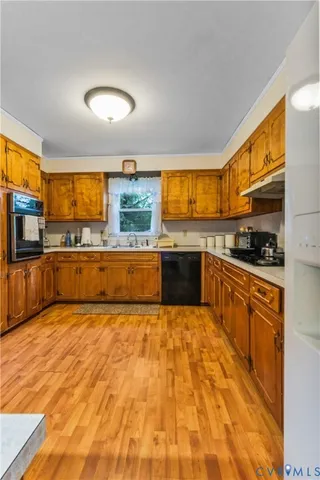 a large kitchen with stainless steel appliances granite countertop a stove and a sink