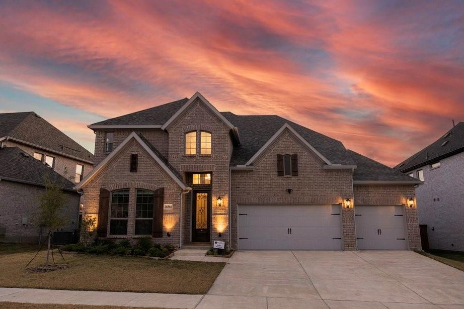 French country style house with brick siding, driveway, and a shingled roof