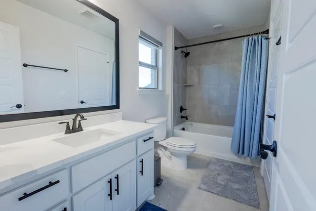 an empty room with a fireplace and windows