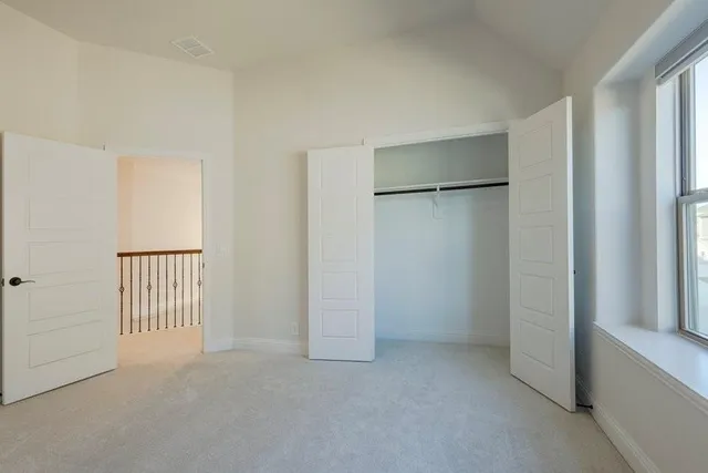 an empty room with windows and closet