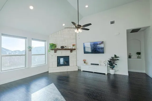 a view of an empty room with a window and wooden floor