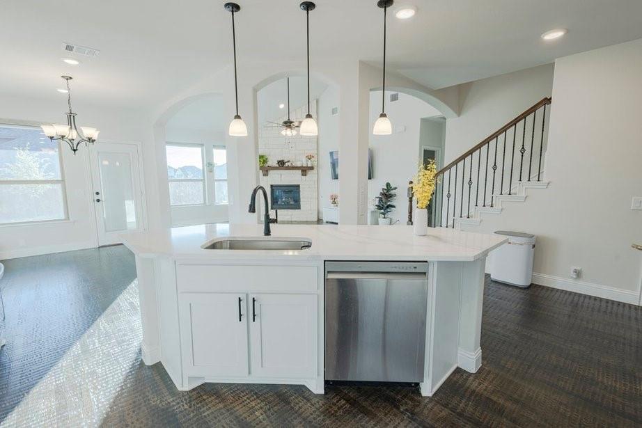 14561 Elion Court Pilot Point, TX 76258 - Photo 36 of 36 Kitchen with open floor plan, hanging light fixtures, dishwasher, light stone countertops, and white cabinets