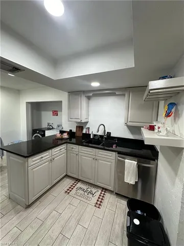 a kitchen with granite countertop a sink and cabinets