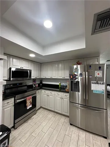 a kitchen with granite countertop a refrigerator and a stove top oven