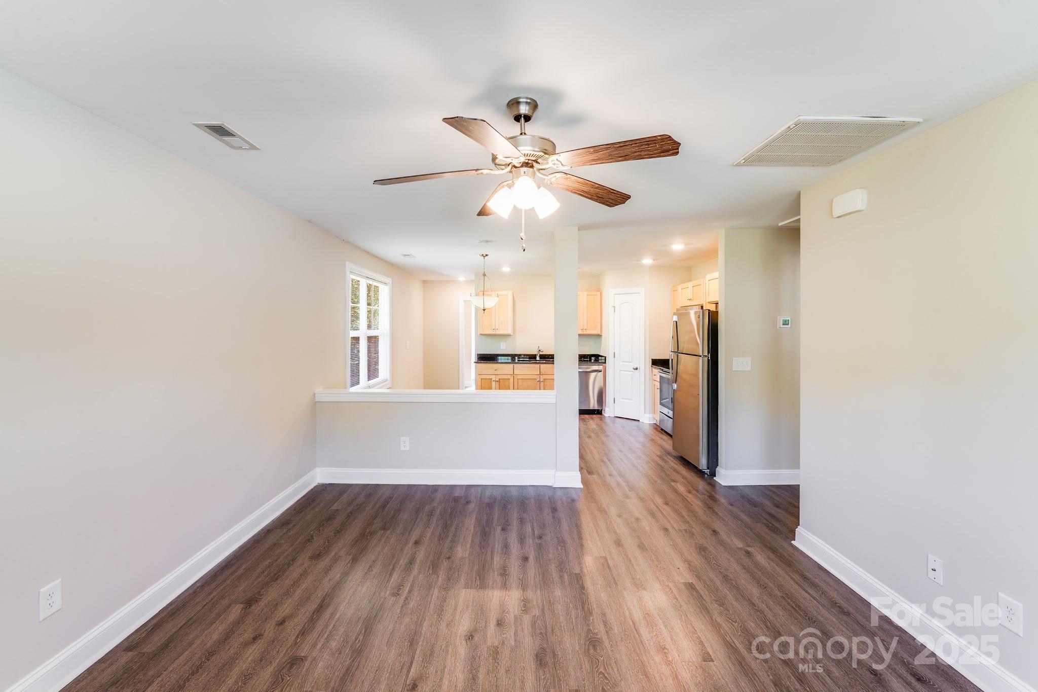 3133 Roberta Road Concord, NC 28027 - Photo 8 of 22 a view of a big room with wooden floor and a chandelier fan