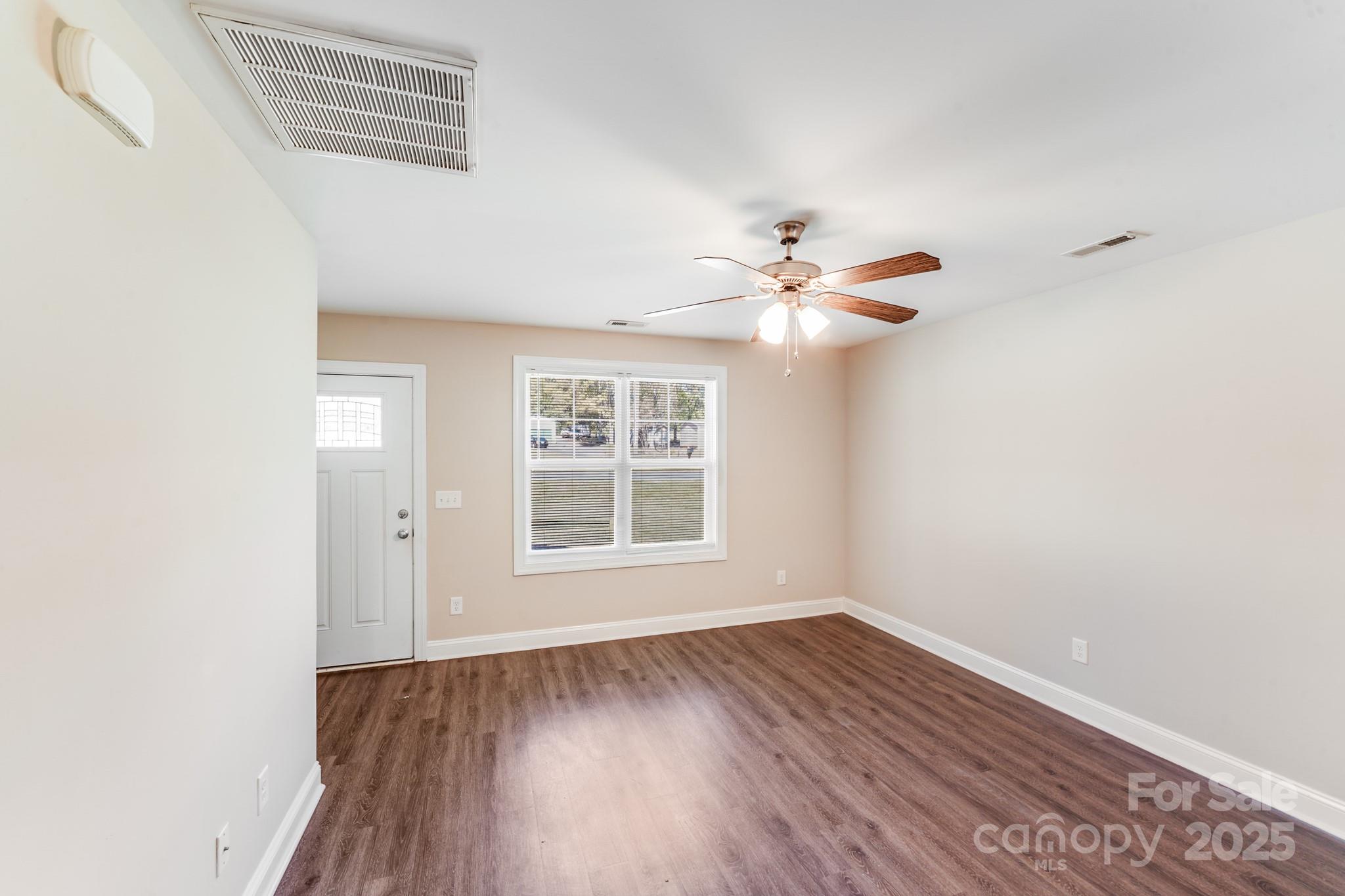3133 Roberta Road Concord, NC 28027 - Photo 10 of 22 an empty room with wooden floor fan and windows