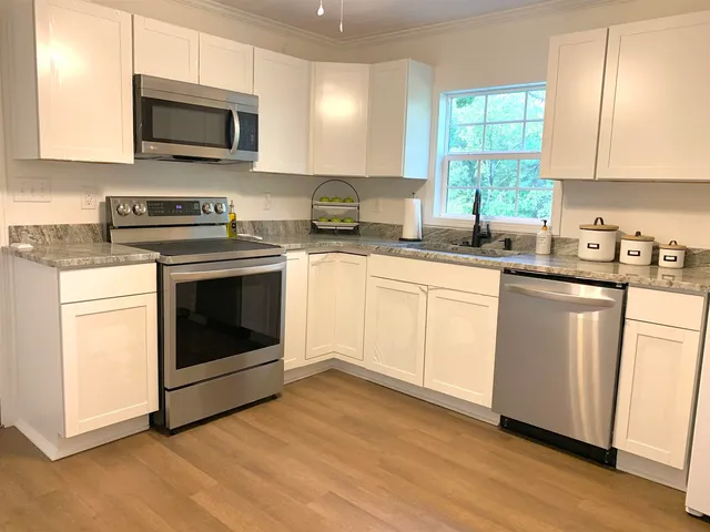 a kitchen with cabinets stainless steel appliances a sink and a microwave