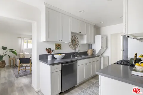 a kitchen with stainless steel appliances granite countertop a sink stove and cabinets