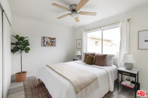 a bedroom with a bed and a plant in it