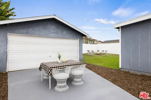 a roof deck with table and chairs and potted plants