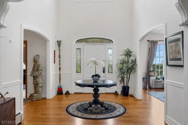 a living room with furniture a clock on wall and a window