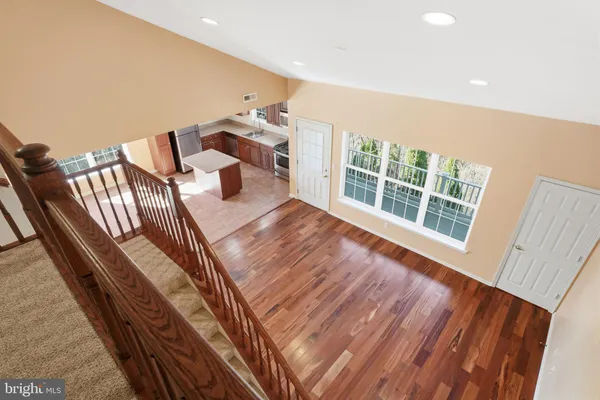 a view of an empty room with wooden floor and windows