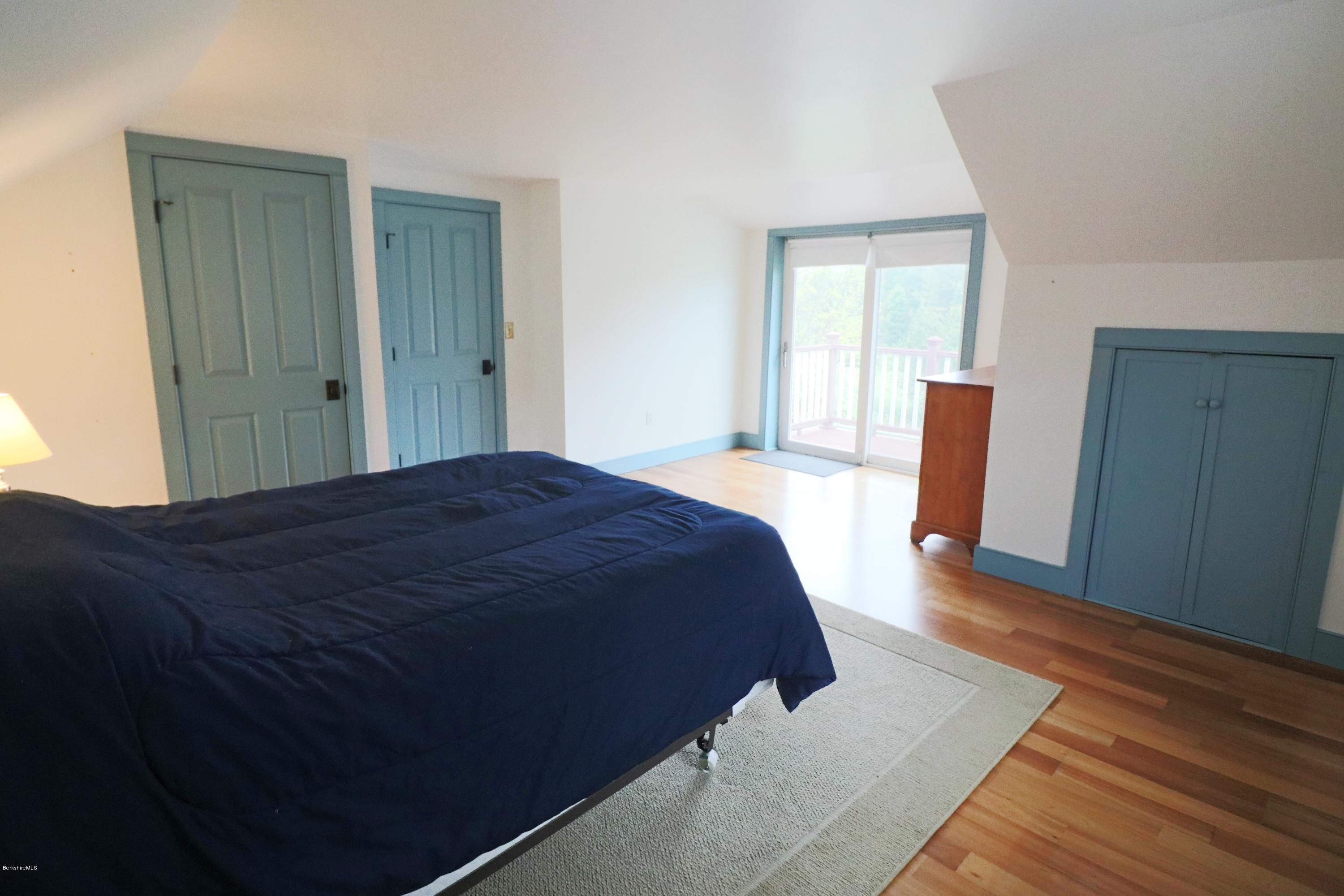 209 State Road Richmond, MA 01201 - Photo 22 of 38 a spacious bedroom with a bed and wooden floor