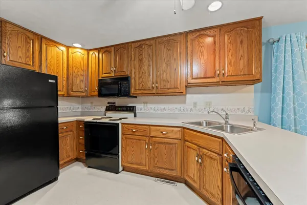 a kitchen with stainless steel appliances granite countertop a refrigerator stove top oven a sink and dishwasher